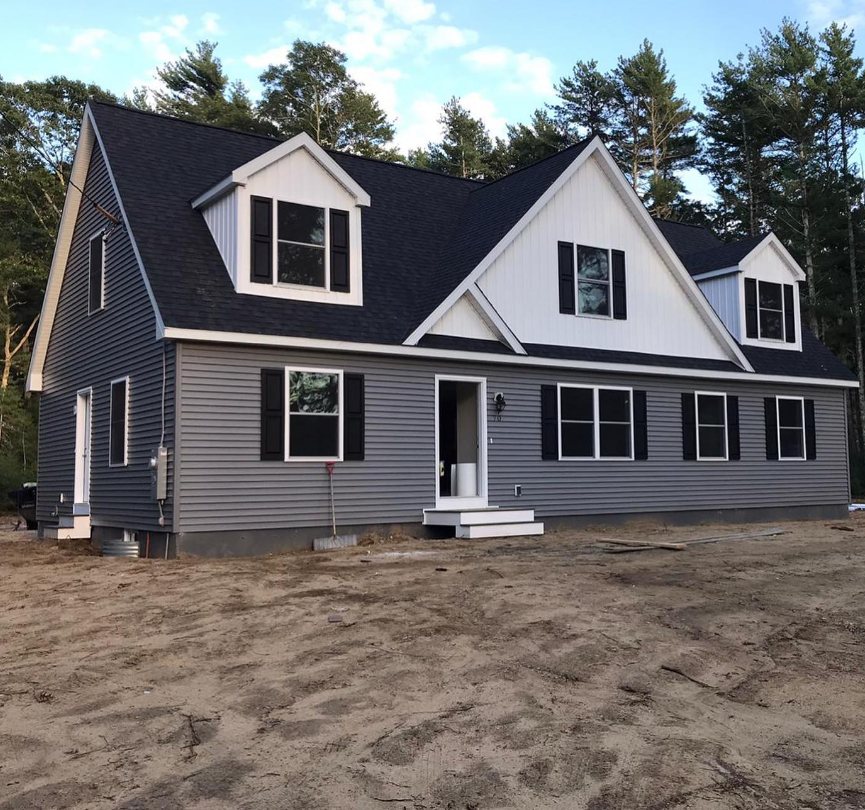 New construction home with gray siding and black shutters