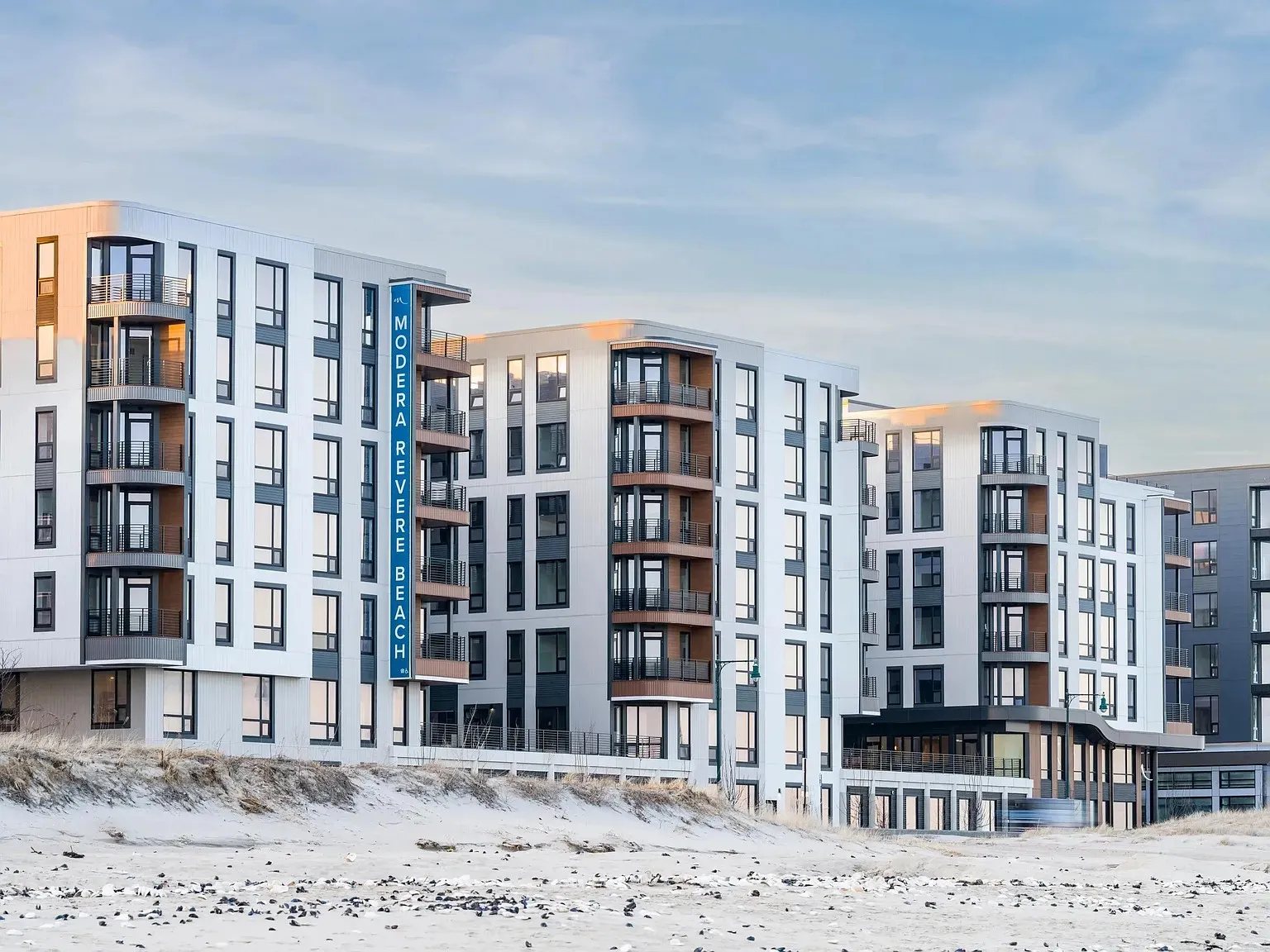Residential building with a light panel facade and balconies facing Revere Beach