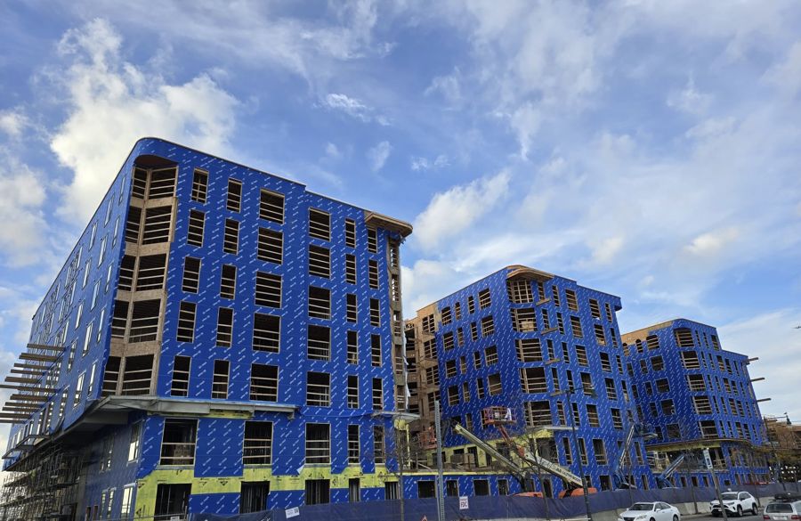 Multifamily buildings under construction fully wrapped in blue air and water barrier