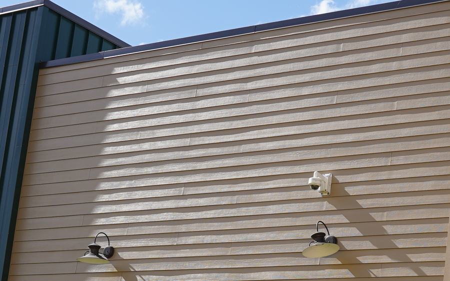 Close view of horizontal lap siding with gooseneck wall lights